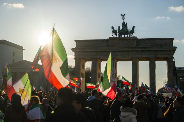 01 March 2026, Berlin: People celebrate the death of Iran's supreme leader, Ayatollah Khamenei during a demonstration against the Iranian mullah regime on Pariser Platz in front of the Brandenburg Gate. Photo: Christophe Gateau/dpa
