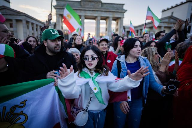 01 March 2026, Berlin: People celebrate the death of Iran's supreme leader, Ayatollah Khamenei during a demonstration against the Iranian mullah regime on Pariser Platz in front of the Brandenburg Gate. Photo: Christoph Soeder/dpa