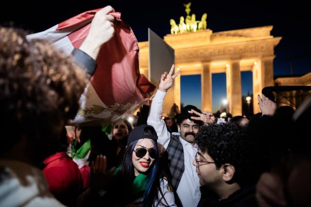 01 March 2026, Berlin: People celebrate the death of Iran's supreme leader, Ayatollah Khamenei during a protest under the slogan "Freedom for Iran under the leadership of Prince Reza Pahlavi" at the Brandenburg Gate. Photo: Christoph Soeder/dpa