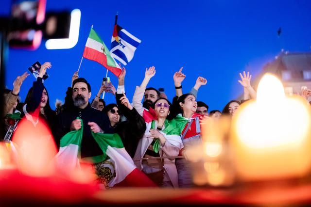 01 March 2026, Berlin: People celebrate the death of Iran's supreme leader, Ayatollah Khamenei during a protest under the slogan "Freedom for Iran under the leadership of Prince Reza Pahlavi" at the Brandenburg Gate. Photo: Christoph Soeder/dpa