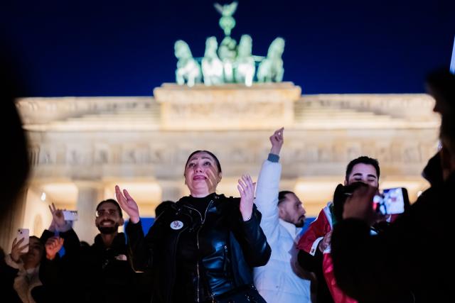 01 March 2026, Berlin: People celebrate the death of Iran's supreme leader, Ayatollah Khamenei during a protest under the slogan "Freedom for Iran under the leadership of Prince Reza Pahlavi" at the Brandenburg Gate. Photo: Christoph Soeder/dpa