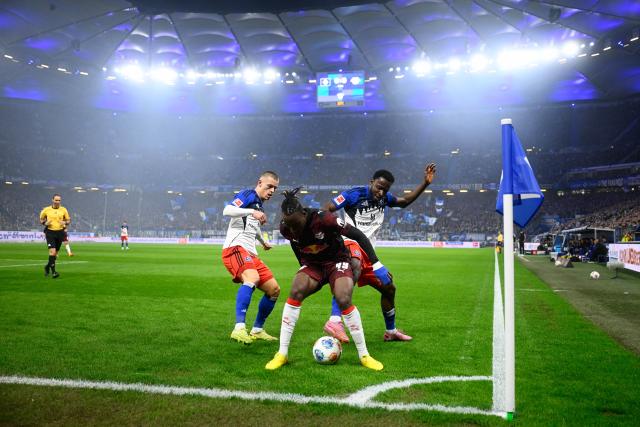 01 March 2026, Hamburg: Hamburger's Miro Muheim (L) and Philip Otele (R) battles for the ball with Leipzig's Yan Diomande during the German Bundesliga soccer match between Hamburger SV and RB Leipzig at Volksparkstadion. Photo: Gregor Fischer/dpa - WICHTIGER HINWEIS: Gemäß den Vorgaben der DFL Deutsche Fußball Liga bzw. des DFB Deutscher Fußball-Bund ist es untersagt, in dem Stadion und/oder vom Spiel angefertigte Fotoaufnahmen in Form von Sequenzbildern und/oder videoähnlichen Fotostrecken zu verwerten bzw. verwerten zu lassen.