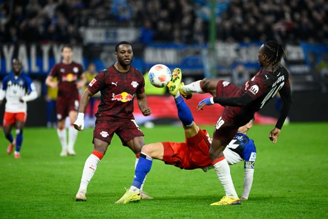 01 March 2026, Hamburg: Hamburger's Miro Muheim (C) battles for the ball with Leipzig's Ridle Baku (L) and Yan Diomande during the German Bundesliga soccer match between Hamburger SV and RB Leipzig at Volksparkstadion. Photo: Gregor Fischer/dpa - WICHTIGER HINWEIS: Gemäß den Vorgaben der DFL Deutsche Fußball Liga bzw. des DFB Deutscher Fußball-Bund ist es untersagt, in dem Stadion und/oder vom Spiel angefertigte Fotoaufnahmen in Form von Sequenzbildern und/oder videoähnlichen Fotostrecken zu verwerten bzw. verwerten zu lassen.