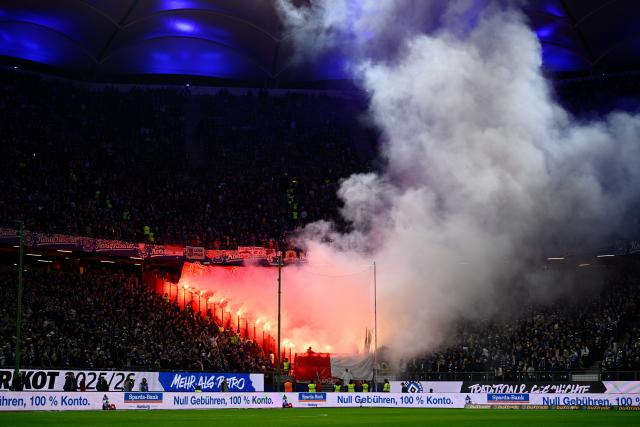01 March 2026, Hamburg: Leipzig fans burn flares in the stands during the German Bundesliga soccer match between Hamburger SV and RB Leipzig at Volksparkstadion. Photo: Gregor Fischer/dpa - WICHTIGER HINWEIS: Gemäß den Vorgaben der DFL Deutsche Fußball Liga bzw. des DFB Deutscher Fußball-Bund ist es untersagt, in dem Stadion und/oder vom Spiel angefertigte Fotoaufnahmen in Form von Sequenzbildern und/oder videoähnlichen Fotostrecken zu verwerten bzw. verwerten zu lassen.