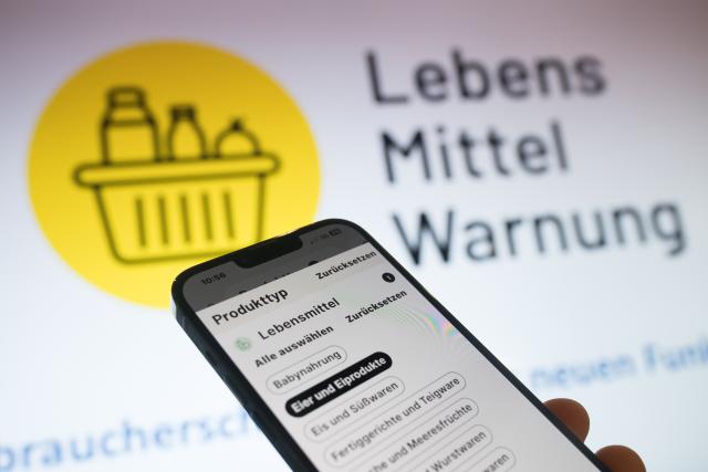 FILED - 18 June 2024, Berlin: The category selection of the "Lebensmittelwarnung.de" app can be seen in front of the Apple logo during a press conference held by the Federal Office of Consumer Protection and Food Safety. A district office is warning against the consumption of a honey paste sold on Amazon because it contains a hidden potency drug. Photo: Sebastian Gollnow/dpa