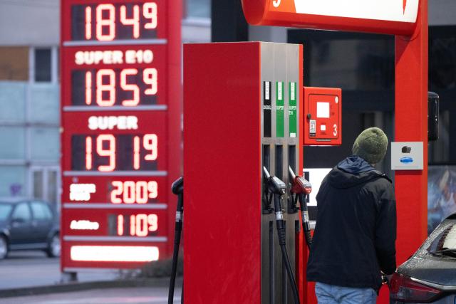 03 March 2026, Saxony, Dresden: A man is filling up a car at a gas station in front of a price board. Photo: Sebastian Kahnert/dpa