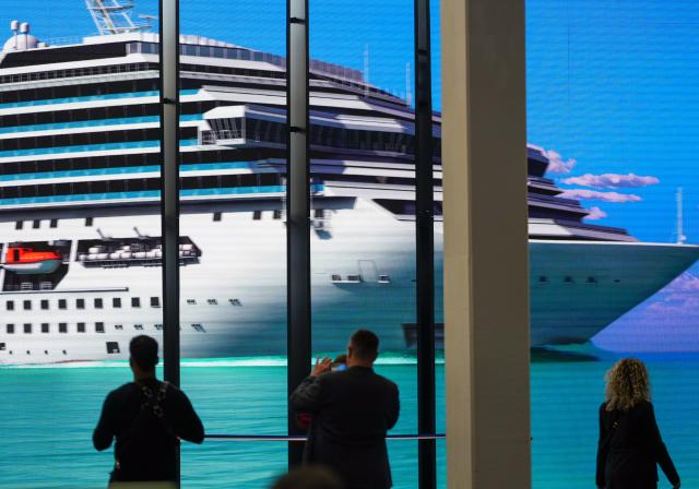 03 March 2026, Berlin: Visitors stand in front of a video screen showing a cruise ship at the Dominican Republic's stand in Hall 21 during the opening day of the International Tourism Exchange (ITB). Photo: Soeren Stache/dpa