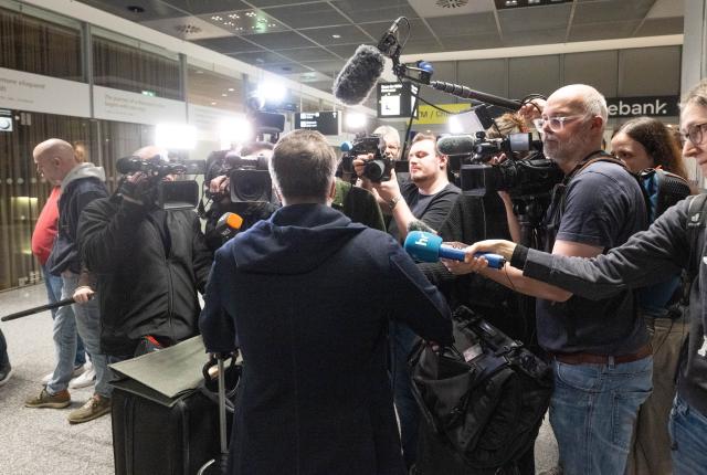 03 March 2026, Hesse, Frankfurt/M.: A passenger is surrounded by camera crews after landing in Frankfurt from Dubai. Tens of thousands of tourists remain stranded in the Gulf states following the outbreak of war in Iran. Photo: Boris Roessler/dpa