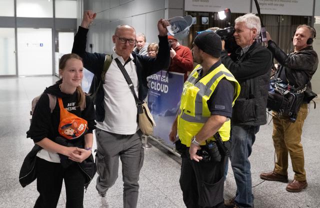 03 March 2026, Hesse, Frankfurt/M.: A passenger cheers after landing at Frankfurt Airport from Dubai. Tens of thousands of tourists remain stranded in the Gulf states following the outbreak of war in Iran. Photo: Boris Roessler/dpa