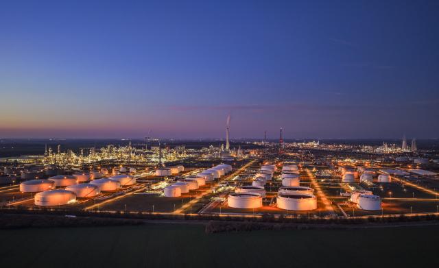 03 March 2026, Saxony-Anhalt, Leuna: A view of the illuminated facilities of the Total Energies refinery in the Leuna Chemical Park (Schkopau power plant in the background). The Leuna refinery is a complex crude oil refinery with conversion plants for the production of fuels and petrochemical precursors and is one of the most important petroleum processing sites in Germany. Photo: Jan Woitas/dpa
