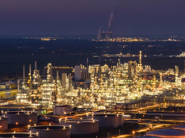 03 March 2026, Saxony-Anhalt, Leuna: A view of the illuminated facilities of the Total Energies refinery in the Leuna Chemical Park (Schkopau power plant in the background). The Leuna refinery is a complex crude oil refinery with conversion plants for the production of fuels and petrochemical precursors and is one of the most important petroleum processing sites in Germany. Photo: Jan Woitas/dpa