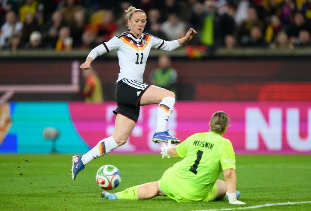 03 March 2026, Saxony, Dresden: Germany's Lea Schueller (L) scores her side's fifth goal against Slovenia's goalkeeper Zala Mersnik during the 2027 FIFA Women's World Cup qualifier League A, Group D, soccer match between Germany and Slovenia at the Rudolf-Harbig-Stadion Photo: Robert Michael/dpa
