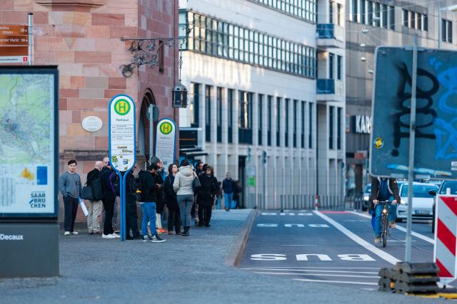 04 March 2026, Saarland, Saarbruecken: Passengers wait at a bus stop in front of City Hall as warning strikes continue to disrupt public transportation. Photo: Laszlo Pinter/dpa