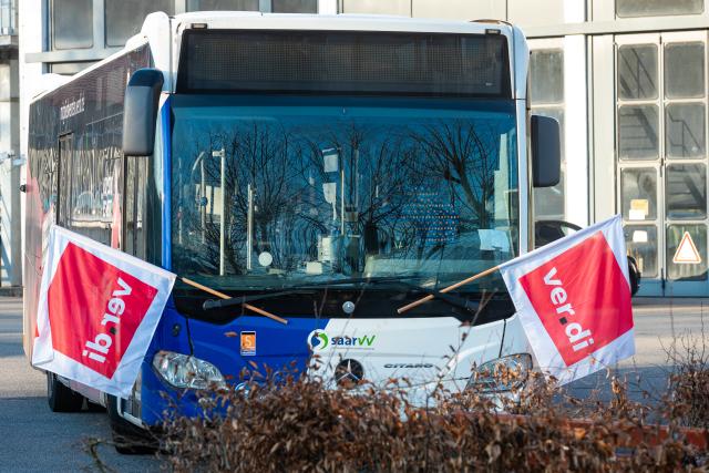 04 March 2026, Saarland, Saarbruecken: Two Verdi union flags are fixed to a bus as vehicles stand at a standstill once again at the Saarbahn GmbH bus depot. Photo: Laszlo Pinter/dpa