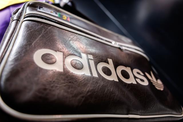 04 March 2026, Bavaria, Herzogenaurach: The logo and lettering of sports equipment manufacturer Adidas AG are prominently displayed on a bag exhibited at the edge of the company's annual press conference. Photo: Daniel Karmann/dpa
