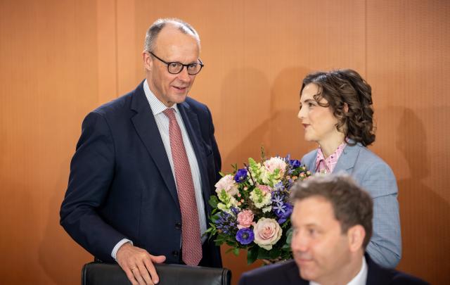 04 March 2026, Berlin: German Chancellor Friedrich Merz (L) presents flowers to Elisabeth Kaiser, Minister of State and Federal Government Commissioner for Eastern Germany, before the start of the German Cabinet meeting at the Federal Chancellery. Photo: Michael Kappeler/dpa