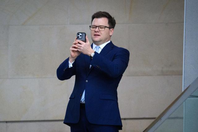 04 March 2026, Berlin: German Minister for the Environment, Climate Protection, Nature Conservation, and Nuclear Safety Carsten Schneider takes photos with his smartphone at the start of the 61st plenary session of the 21st legislative period in the German Bundestag. Photo: Bernd von Jutrczenka/dpa