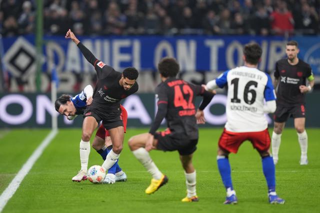 04 March 2026, Hamburg: Hamburger's Rayan Philippe (L) and Bayer Leverkusen's Jarell Quansah battle for the ball during the German Bundesliga soccer match between Hamburger SV and Bayer Leverkusen at the Volksparkstadion. Photo: Marcus Brandt/dpa - IMPORTANT NOTICE: DFL and DFB regulations prohibit any use of photographs as image sequences and/or quasi-video.