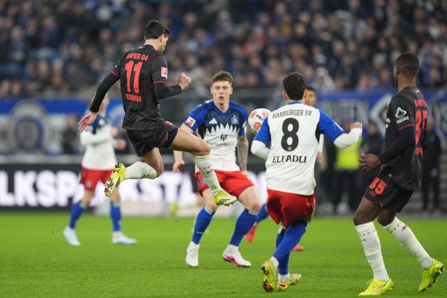 04 March 2026, Hamburg: Bayer Leverkusen's Martin Terrier in action against Hamburger's Nicolai Remberg and Daniel Elfadli during the German Bundesliga soccer match between Hamburger SV and Bayer Leverkusen at the Volksparkstadion. Photo: Marcus Brandt/dpa - IMPORTANT NOTICE: DFL and DFB regulations prohibit any use of photographs as image sequences and/or quasi-video.