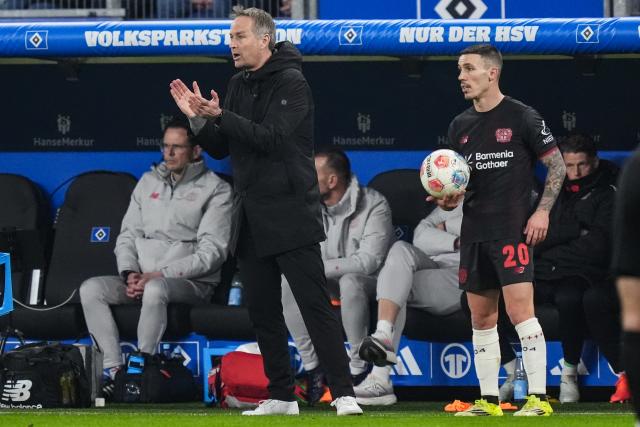 04 March 2026, Hamburg: Bayer Leverkusen's coach Kasper Hjulmand gestures next to Alex Grimaldo during the German Bundesliga soccer match between Hamburger SV and Bayer Leverkusen at the Volksparkstadion. Photo: Marcus Brandt/dpa - IMPORTANT NOTICE: DFL and DFB regulations prohibit any use of photographs as image sequences and/or quasi-video.