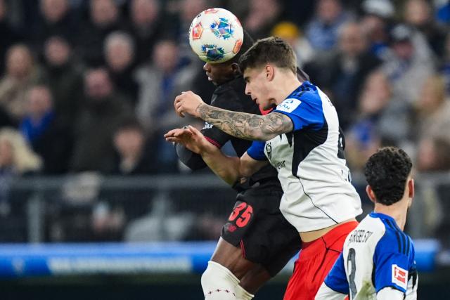 04 March 2026, Hamburg: Bayer Leverkusen's Christian Kofane and Hamburger's Luka Vuskovic battle for a header during the German Bundesliga soccer match between Hamburger SV and Bayer Leverkusen at the Volksparkstadion. Photo: Marcus Brandt/dpa - IMPORTANT NOTICE: DFL and DFB regulations prohibit any use of photographs as image sequences and/or quasi-video.