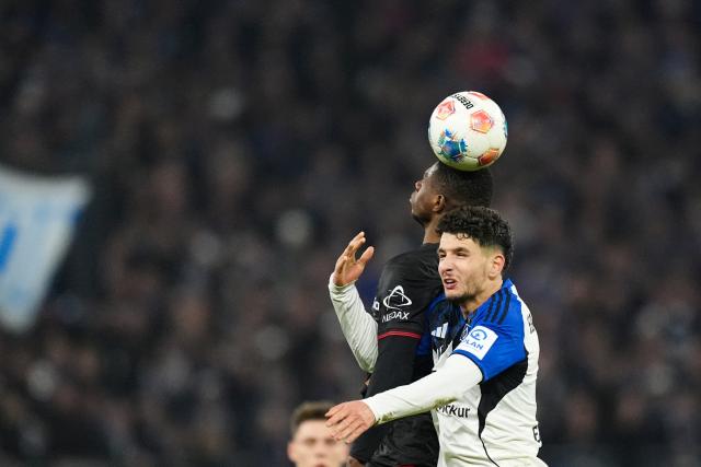 04 March 2026, Hamburg: Bayer Leverkusen's Christian Kofane and Hamburger's Daniel Elfadli (R) battle for the ball during the German Bundesliga soccer match between Hamburger SV and Bayer Leverkusen at the Volksparkstadion. Photo: Marcus Brandt/dpa - IMPORTANT NOTICE: DFL and DFB regulations prohibit any use of photographs as image sequences and/or quasi-video.