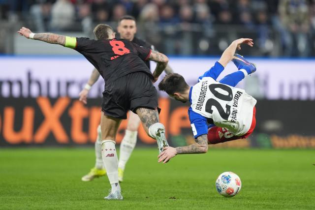 04 March 2026, Hamburg: Bayer Leverkusen's Robert Andrich and Hamburger's Fabio Vieira battle for the ball during the German Bundesliga soccer match between Hamburger SV and Bayer Leverkusen at the Volksparkstadion. Photo: Marcus Brandt/dpa - IMPORTANT NOTICE: DFL and DFB regulations prohibit any use of photographs as image sequences and/or quasi-video.
