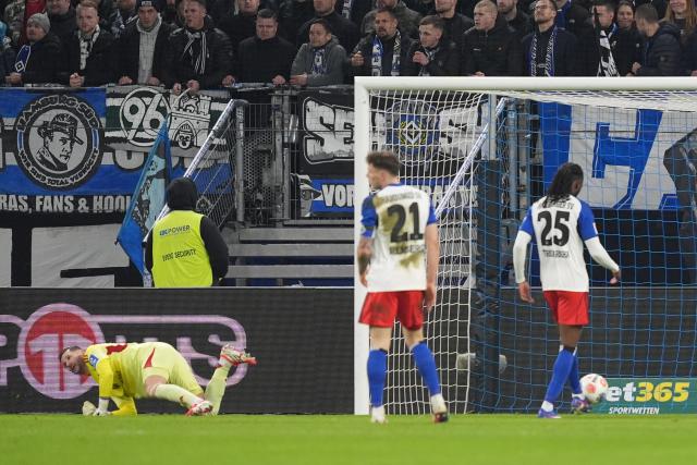 04 March 2026, Hamburg: Hamburger goalkeeper Daniel Heuer Fernandes fails to save Leverkusen's goal by Kofane during the German Bundesliga soccer match between Hamburger SV and Bayer Leverkusen at the Volksparkstadion. Photo: Marcus Brandt/dpa - IMPORTANT NOTICE: DFL and DFB regulations prohibit any use of photographs as image sequences and/or quasi-video.