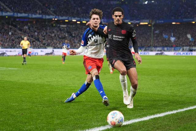 04 March 2026, Hamburg: Bayer Leverkusen's Jarell Quansah (R) and Hamburger's Otto Stange battle for the ball during the German Bundesliga soccer match between Hamburger SV and Bayer Leverkusen at the Volksparkstadion. Photo: Marcus Brandt/dpa - IMPORTANT NOTICE: DFL and DFB regulations prohibit any use of photographs as image sequences and/or quasi-video.