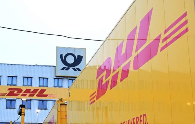 FILED - 07 November 2025, Baden-Wuerttemberg, Koengen: The DHL and Deutsche Post logos seen in front of the DHL parcel center. Photo: Bernd Weißbrod/dpa