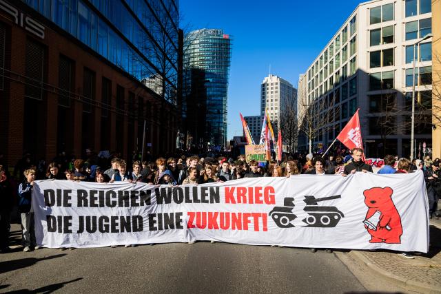 05 March 2026, Berlin: Participants hold up a banner says "The rich want war, young people want a future" during a demonstration, as part of a nationwide school strike against compulsory military service. Photo: Christoph Soeder/dpa
