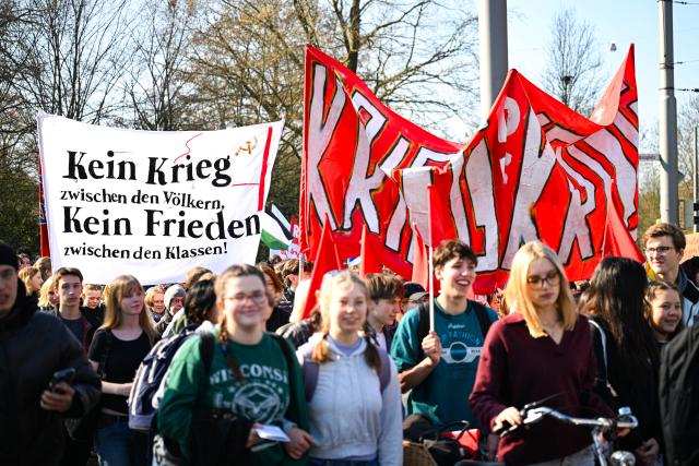 05 March 2026, Bremen: Participants hold flags and a banner during a demonstration, as part of a nationwide school strike against compulsory military service. Photo: Sina Schuldt/dpa