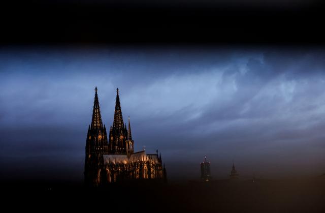 FILED - 28 July 2025, North Rhine-Westphalia, Cologne: The cathedral is illuminated in the morning, seen through a railing. Photo: Oliver Berg/dpa