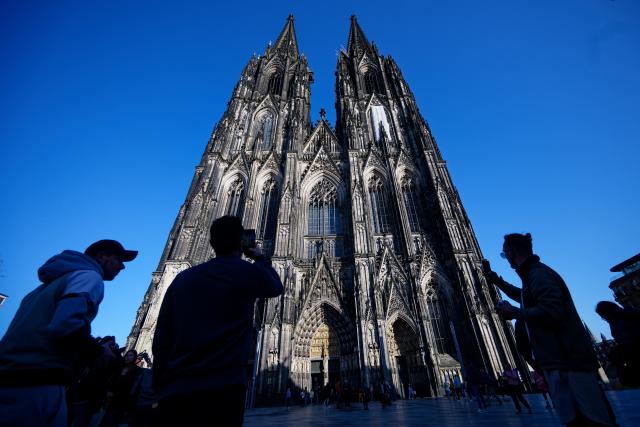 05 March 2026, North Rhine-Westphalia, Cologne: Tourists taking photos of Cologne Cathedral. In future, tourists will have to pay admission to Cologne Cathedral. This is to cover the increased costs for the care, protection and ongoing operation of the cathedral, as the cathedral chapter announced at a press conference Photo: Henning Kaiser/dpa