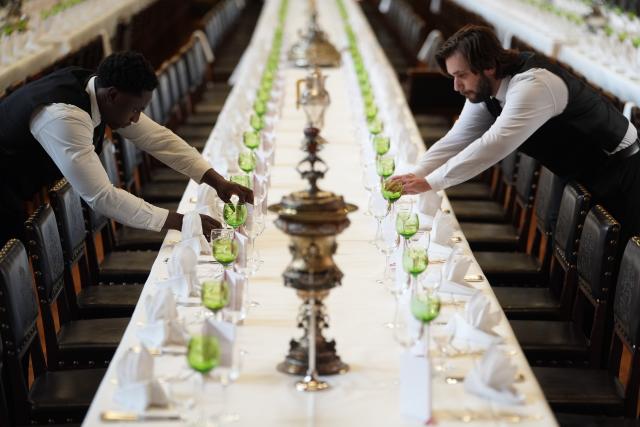 05 March 2026, Hamburg: service employees Gonzalo Anzilutti (R), and Christian Kyei (L), check the wine and water glasses on the tables during the final preparations for the Hamburg Senate's traditional Matthiae meal at the town hall. The Hamburg Matthiae banquet is considered to be the oldest banquet still celebrated in the world. The guests of honor at this year's Matthiae-Mahl will be former German Chancellor Merkel and EU Council President Antonio Costa. Photo: Marcus Brandt/dpa