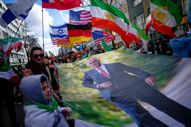 FILED - 01 March 2026, North Rhine-Westphalia, Duesseldorf: People carry a huge portrait of the exiled son of the deposed Shah of Persia, Reza Pahlavi during a demonstration against the Iranian mullah regime and celebrate the death of Iran's supreme leader, Ayatollah Khamenei. Photo: Henning Kaiser/dpa