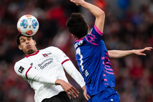 FILED - 28 February 2026, North Rhine-Westphalia, Leverkusen: Bayer Leverkusen's Jarell Quansah (L) and Mainz's Jae-sung Lee battle for the ball during the German Bundesliga soccer match between Bayer Leverkusen and FSV Mainz 05 at BayArena. Photo: Marius Becker/dpa - WICHTIGER HINWEIS: Gemäß den Vorgaben der DFL Deutsche Fußball Liga bzw. des DFB Deutscher Fußball-Bund ist es untersagt, in dem Stadion und/oder vom Spiel angefertigte Fotoaufnahmen in Form von Sequenzbildern und/oder videoähnlichen Fotostrecken zu verwerten bzw. verwerten zu lassen.