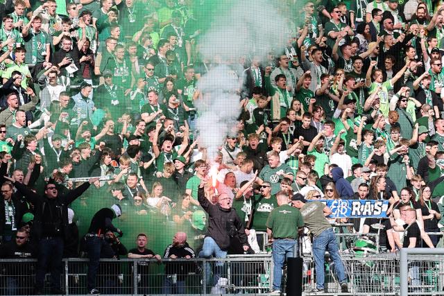 07 March 2026, Lower Saxony, Wolfsburg: Wolfsburg fans cheer in the stands during the German Bundesliga soccer match between VfL Wolfsburg and Hamburger SV at the Volkswagen Arena. Photo: Andreas Gora/dpa - IMPORTANT NOTE: In accordance with the regulations of the DFL German Football League and the DFB German Football Association, it is prohibited to utilize or have utilized photographs taken in the stadium and/or of the match in the form of sequential images and/or video-like photo series.