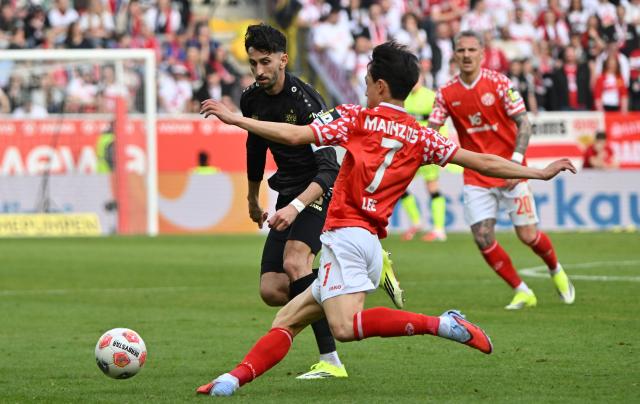 07 March 2026, Rhineland-Palatinate, Mainz: Mainz' Jae-sung Lee and Stuttgart's Atakan Karazor battle for the ball during the German Bundesliga soccer match between FSV Mainz 05 and VfB Stuttgart at the Mewa Arena. Photo: Torsten Silz/dpa - IMPORTANT NOTICE: DFL and DFB regulations prohibit any use of photographs as image sequences and/or quasi-video.