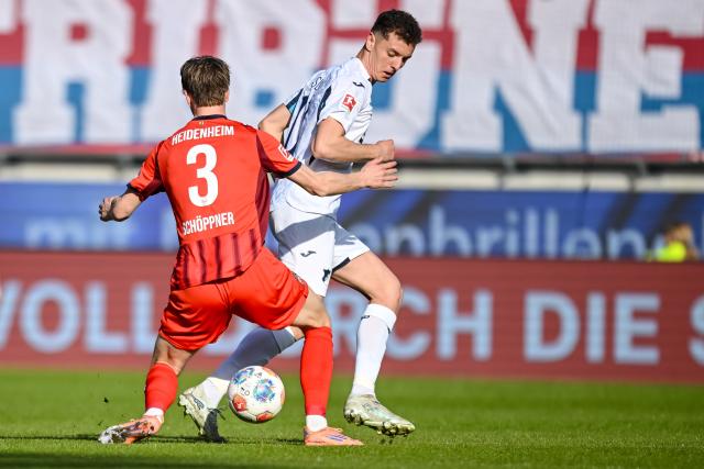 07 March 2026, Baden-Württemberg, Heidenheim: Heidenheim's Jan Schoeppner (L) and Hoffenheim's Fisnik Asllani battle for the ball during the German Bundesliga soccer match between FC Heidenheim and TSG 1899 Hoffenheim at the Voith-Arena. Photo: Harry Langer/dpa - IMPORTANT NOTICE: DFL and DFB regulations prohibit any use of photographs as image sequences and/or quasi-video.