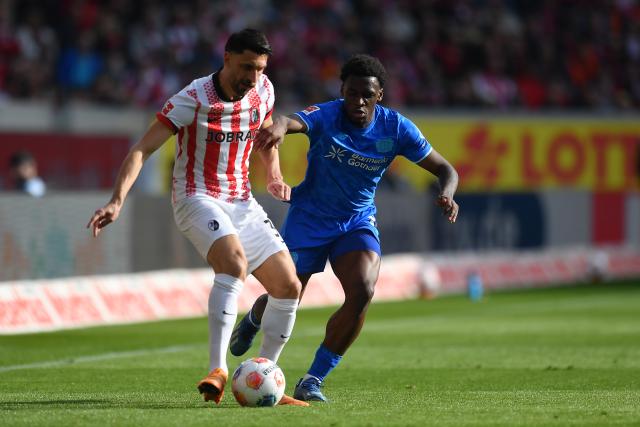 07 March 2026, Freiburg Im Breisgau: Bayer Leverkusen's Ernest Poku (R) and Freiburg's Vincenzo Grifo battle for the ball during the German Bundesliga soccer match between SC Freiburg and Bayer Leverkusen at the Europa-Park Stadium. Photo: Achim Keller/dpa - IMPORTANT NOTICE: DFL and DFB regulations prohibit any use of photographs as image sequences and/or quasi-video.