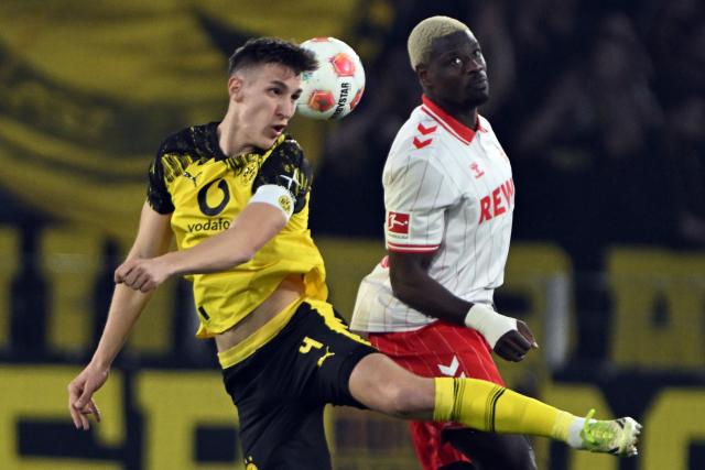 07 March 2026, North Rhine-Westphalia, Cologne: Cologne's Ragnar Ache and Borussia Dortmund's Nico Schlotterbeck battle for the ball during the German Bundesliga soccer match between during the German Bundesliga soccer match between 1. FC Cologne and Borussia Dortmund at the RheinEnergieStadion. Photo: Federico Gambarini/dpa - IMPORTANT NOTE: In accordance with the regulations of the DFL German Football League and the DFB German Football Association, it is prohibited to utilize or have utilized photographs taken in the stadium and/or of the match in the form of sequential images and/or video-like photo series.