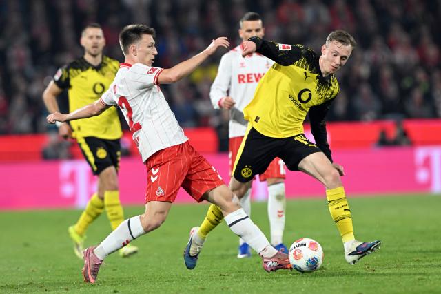 07 March 2026, North Rhine-Westphalia, Cologne: Cologne's Kristoffer Lund and Borussia Dortmund's Maximilian Beier battle for the ball during the German Bundesliga soccer match between 1. FC Cologne and Borussia Dortmund at the RheinEnergieStadion. Photo: Federico Gambarini/dpa - IMPORTANT NOTICE: DFL and DFB regulations prohibit any use of photographs as image sequences and/or quasi-video.