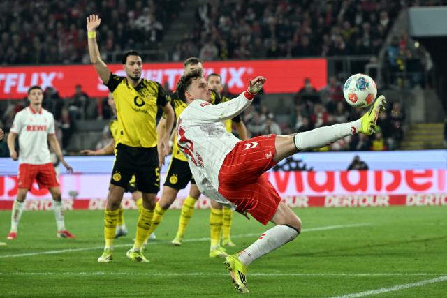 07 March 2026, North Rhine-Westphalia, Cologne: Cologne's Rav van den Berg and Borussia Dortmund's Ramy Bensebaini battle for the ball during the German Bundesliga soccer match between 1. FC Cologne and Borussia Dortmund at the RheinEnergieStadion. Photo: Federico Gambarini/dpa - IMPORTANT NOTICE: DFL and DFB regulations prohibit any use of photographs as image sequences and/or quasi-video.