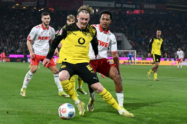 07 March 2026, North Rhine-Westphalia, Cologne: Cologne's Youssoupha Niang and Borussia Dortmund's Julian Brandt in action during the German Bundesliga soccer match between 1. FC Cologne and Borussia Dortmund at the RheinEnergieStadion. Photo: Federico Gambarini/dpa - IMPORTANT NOTICE: DFL and DFB regulations prohibit any use of photographs as image sequences and/or quasi-video.