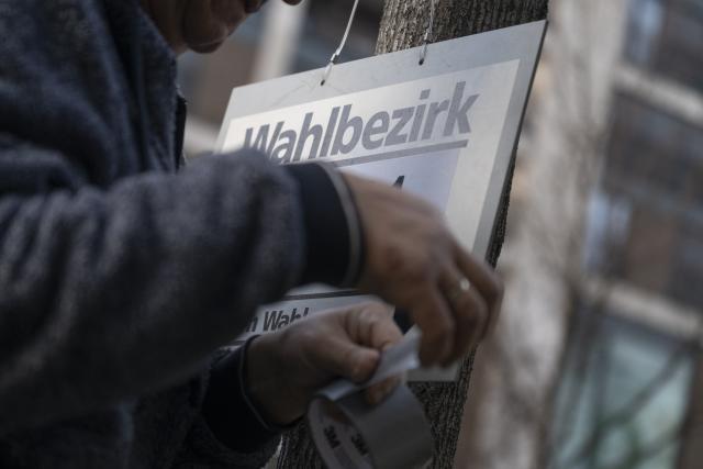 08 March 2026, Baden-Württemberg, Stuttgart: A man attaches a sign reading "Wahlbezirk" (electoral district) to a tree ahead of the state elections to be held in Baden-Wuerttemberg on March 8. Photo: Marijan Murat/dpa