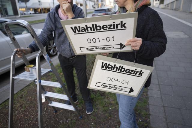 08 March 2026, Baden-Württemberg, Stuttgart: An election worker and a man attach signs in front of a polling station ahead of the state elections to be held in Baden-Wuerttemberg on March 8. Photo: Marijan Murat/dpa