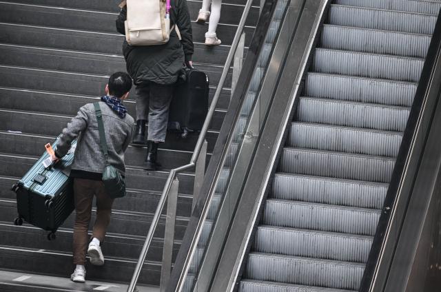 10 March 2026, Berlin: Passengers carry their suitcases up the stairs at Berlin Central Station, as several escalators are out of order. Photo: Britta Pedersen/dpa