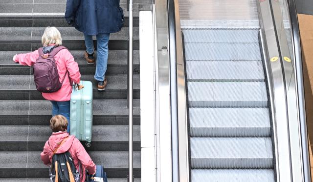 10 March 2026, Berlin: Passengers carry their suitcases up the stairs at Berlin Central Station, as several escalators are out of order. Photo: Britta Pedersen/dpa