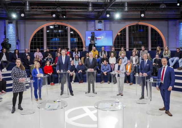 12 March 2026, Rhineland-Palatinate, Mainz: Lead candidates Rebecca Ruppert (Left Party), Katrin Eder (Green Party), Alexander Schweitzer (Social Democratic Party), Gordon Schnieder (Christian Democratic Union), Daniela Schmitt (Free Democratic Party), Joachim Streit (Free Voters), and Jan Bollinger (Alternative for Germany) stand together during the SWR 'Wahlarena' at the Alte Lokhalle in Mainz. Photo: Andreas Arnold/dpa